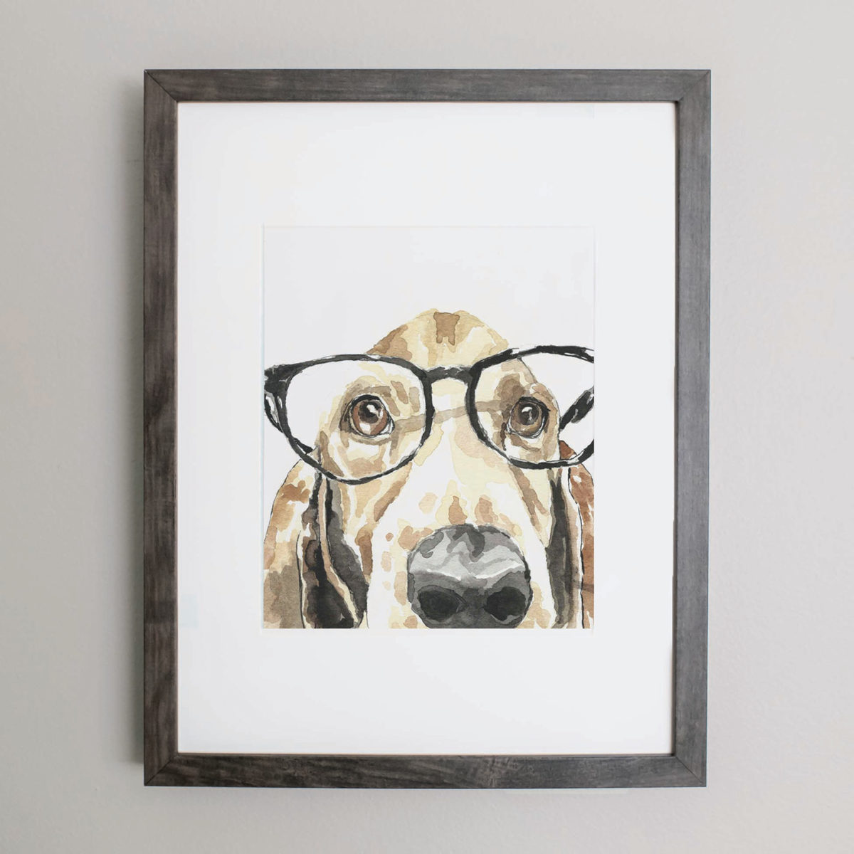 Watercolor of a Basset Hound wearing glasses in a gray frame