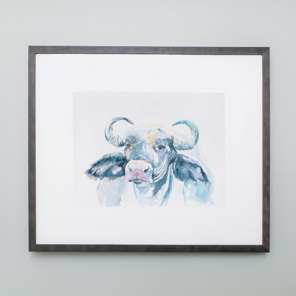 Watercolor of a blue African buffalo in a gray frame