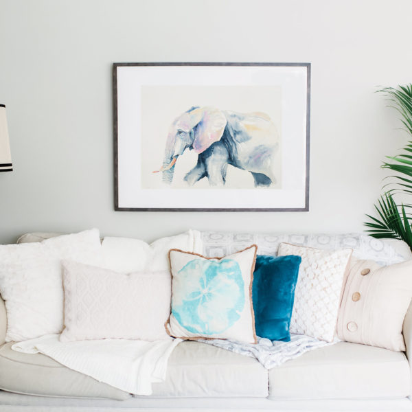 Watercolor of blue elephant above couch