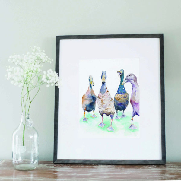 Watercolor of Indian Runner Ducklings in a gray frame next to flowers
