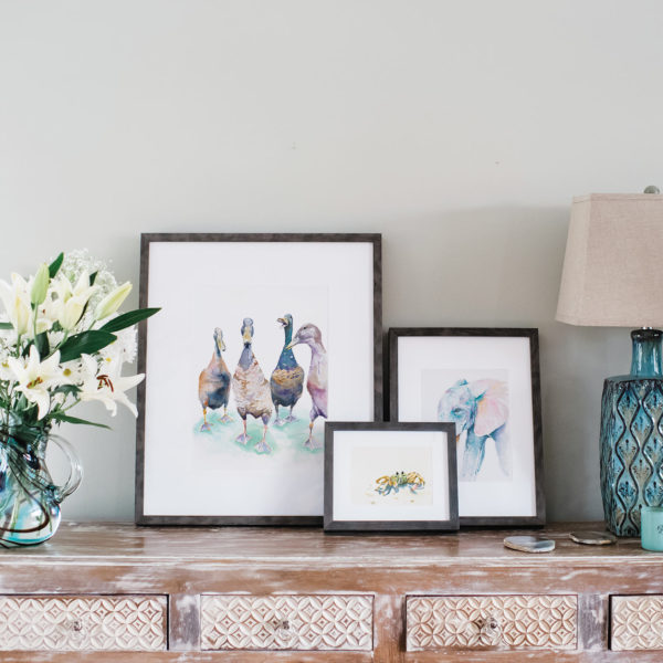 Watercolor samples in gray frames next to flowers