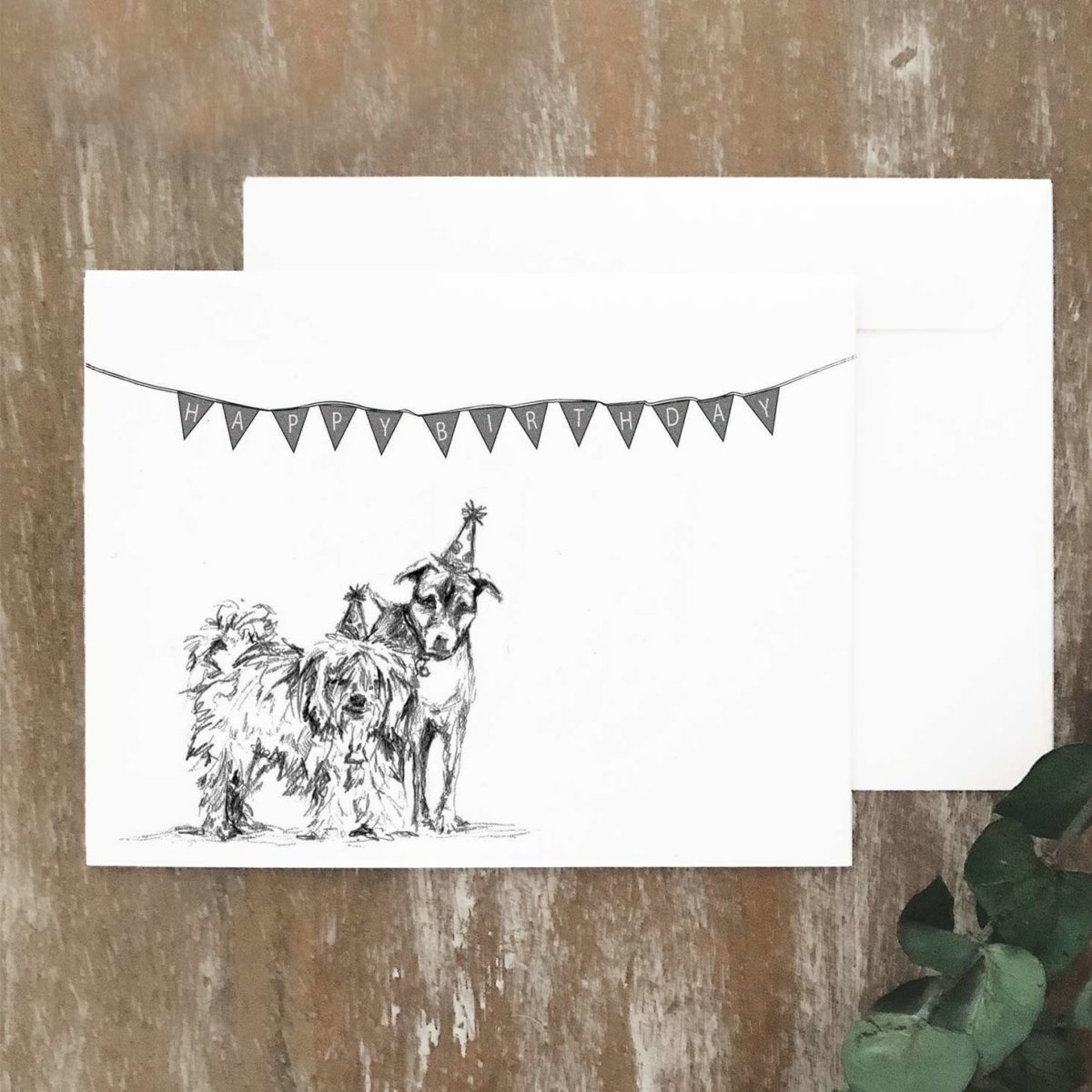A2 greeting card of two dogs wearing birthday hats and standing under a birthday sign