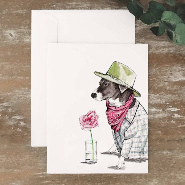 A2 greeting card of a black and white dog wearing a green hat and sitting next to a flower
