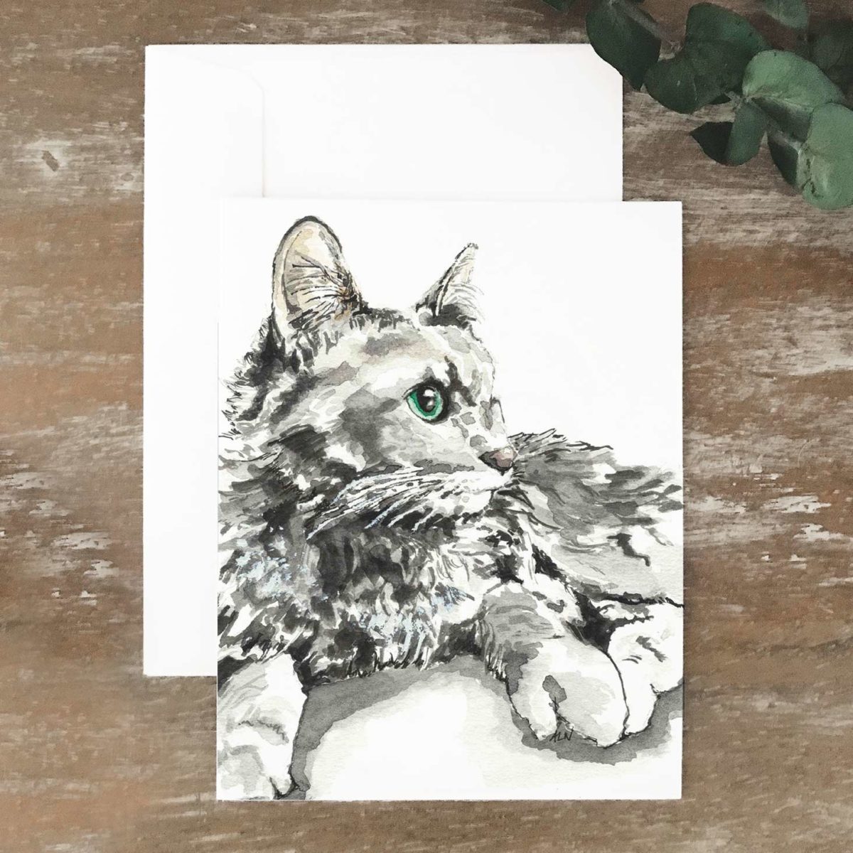 A2 greeting card of a gray and white cat with green eyes